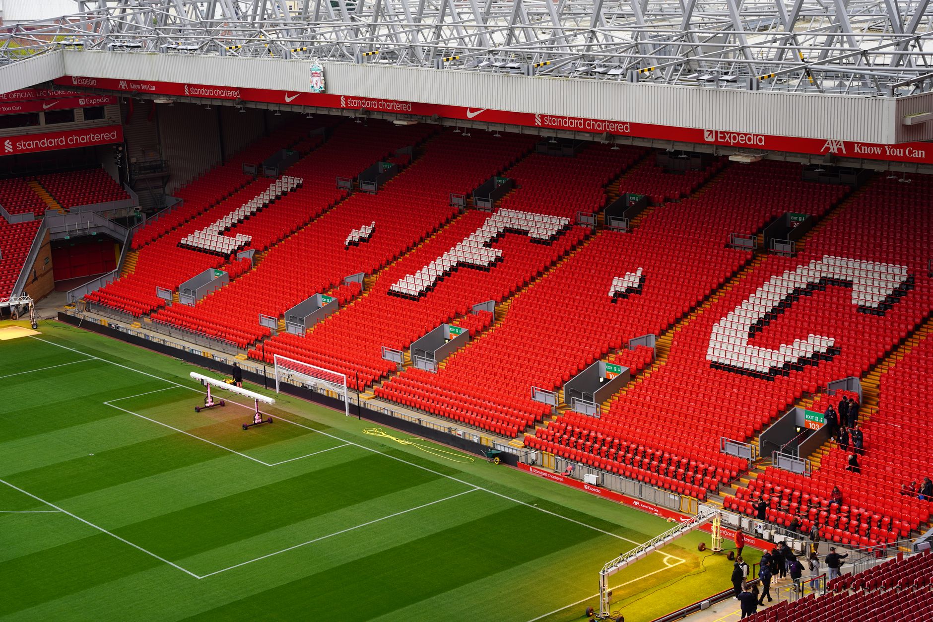 Pemandangan tempat duduk Stadion Anfield dengan huruf LFC yang mencolok. Potret sempurna tempat Liverpool FC yang ikonik.