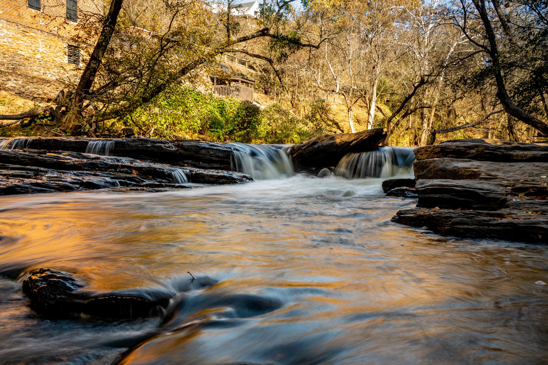 Pemandangan air terjun yang tenang dikelilingi oleh dedaunan musim gugur di Georgia yang indah.