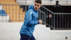 Pemain sepak bola yang fokus melakukan pemanasan di lapangan di Baku, Azerbaijan, menunjukkan tekad atletik.