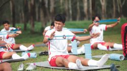 Sekelompok pemain sepak bola muda berlatih dengan band resistensi di luar ruangan di Jakarta, Indonesia.
