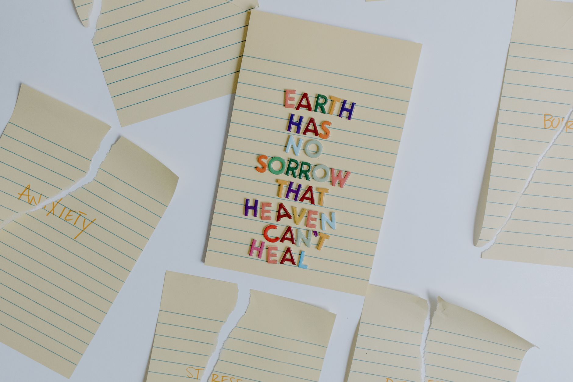 Flat lay kreatif dari kutipan inspiratif dengan kertas robek yang menekankan penyembuhan dan kesehatan mental.